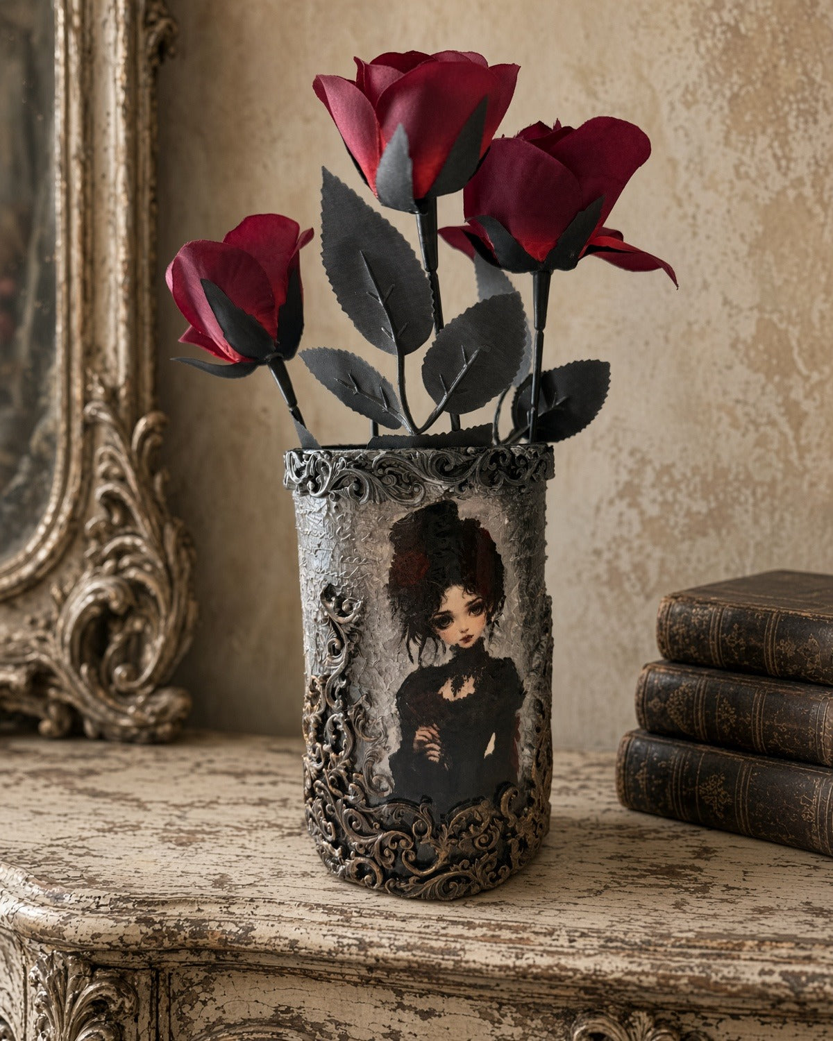 Handmade decoupage glass vase with gothic lady in black dress portrait and silver-black relief scrolls, red roses, on cream table