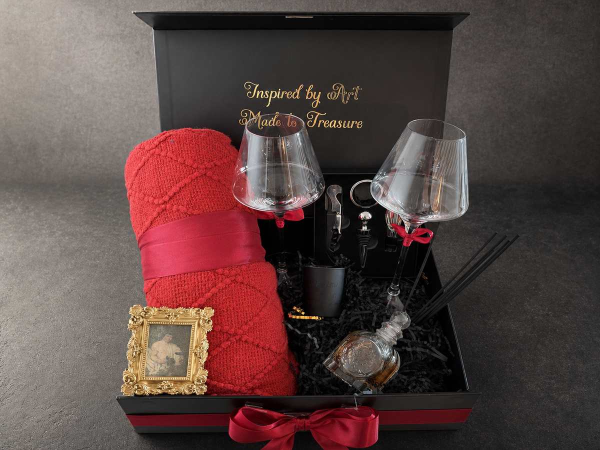 Open Caravaggio Bacchus wine gift box with red throw, wine glasses and framed art