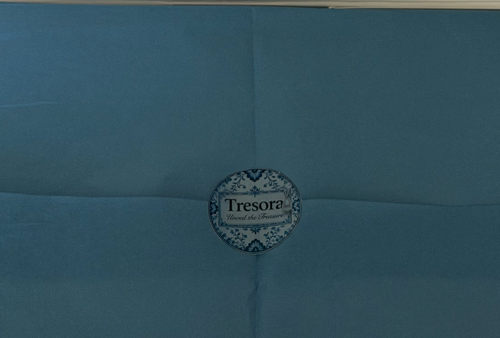 Floral TRESORA sticker on blue tissue in the Vermeer Girl with a Pearl Earring gift box
