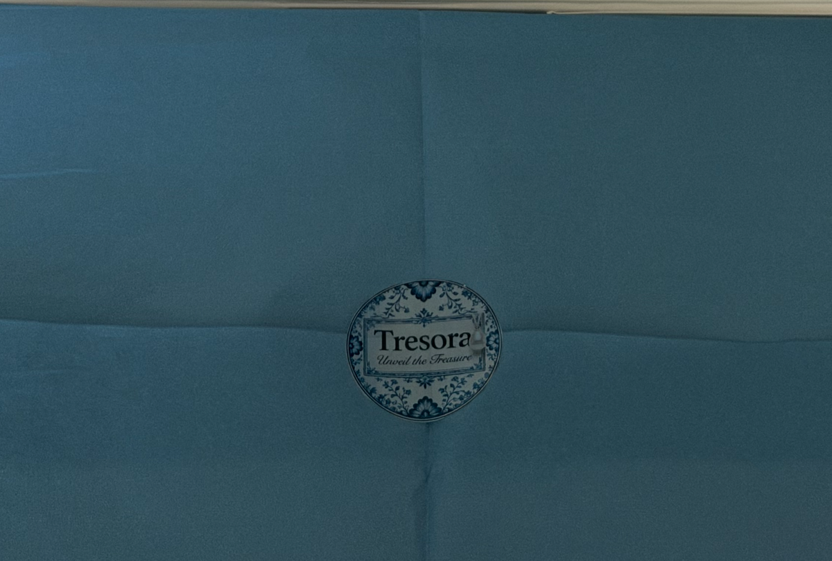 Floral TRESORA sticker on blue tissue in the Vermeer Girl with a Pearl Earring gift box