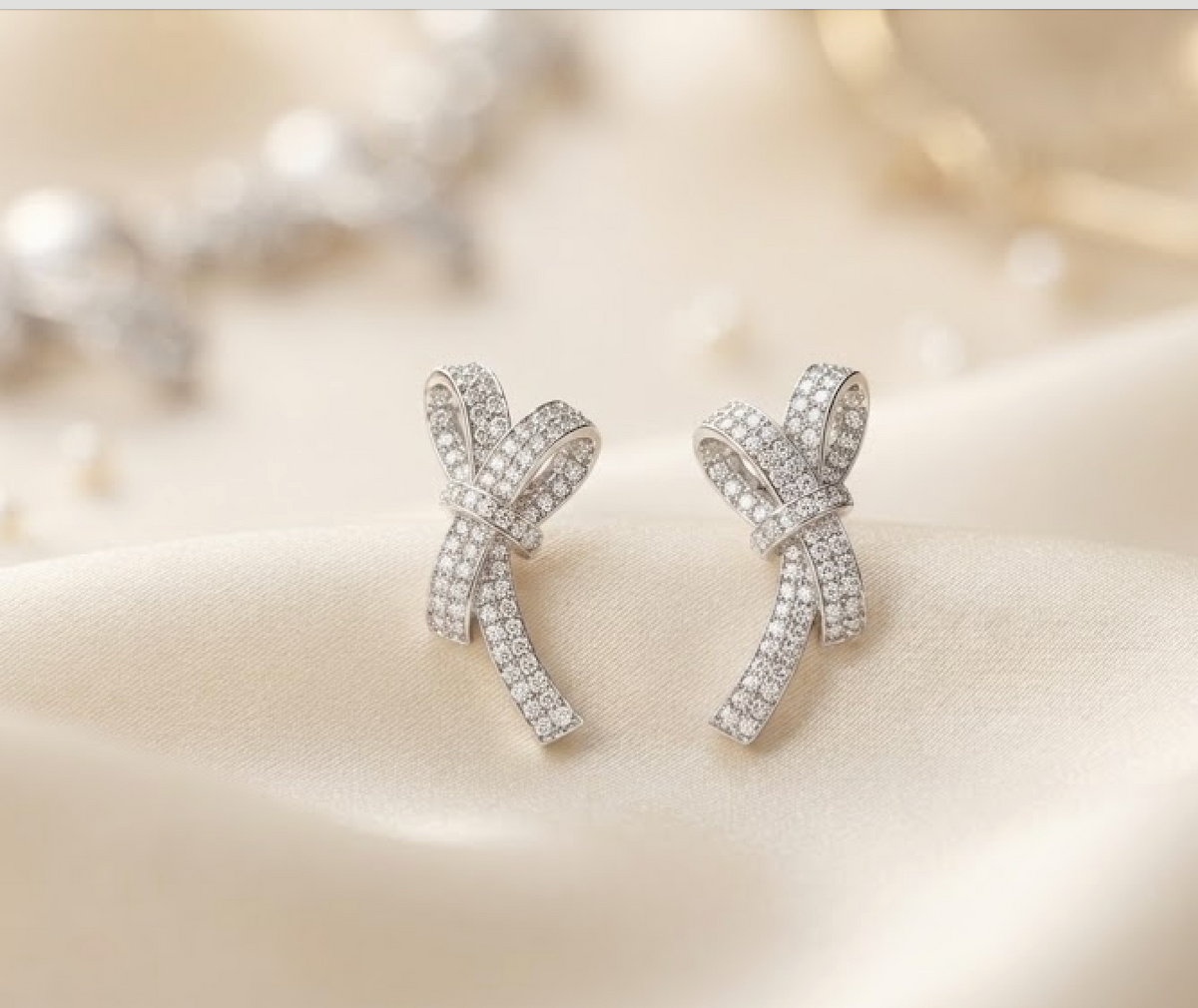 Silver bow-shaped stud earrings on satin for the Paris Gift Box