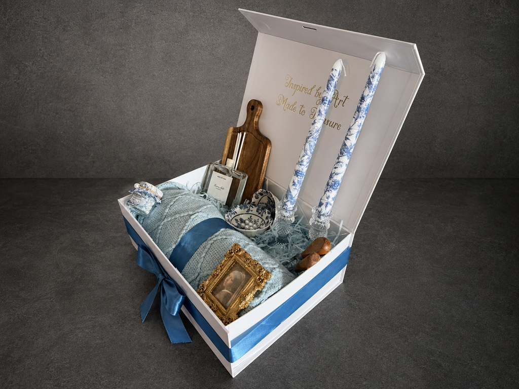 Open Vermeer Girl with a Pearl Earring gift box with blue ribbon, rolled blanket and patterned candles