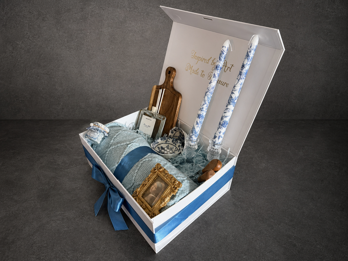 Open Vermeer Girl with a Pearl Earring gift box with blue ribbon, rolled blanket and patterned candles