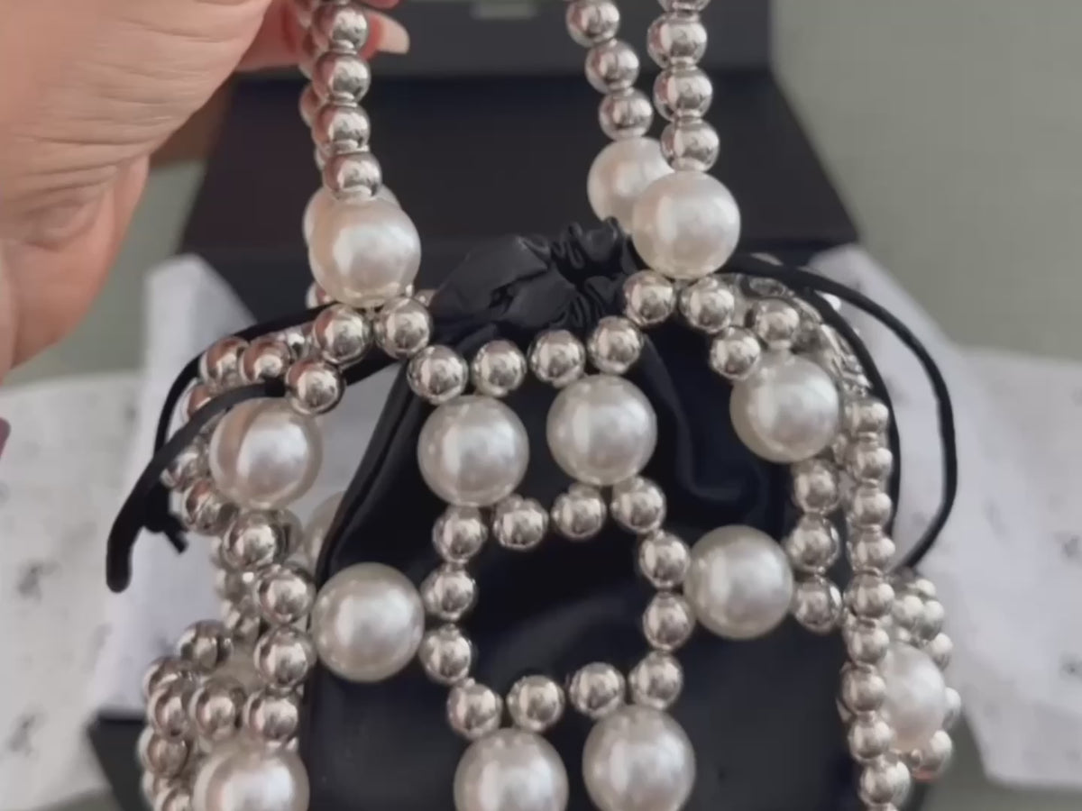 Packing the TRESORA Paris Gift Box: pearl beaded mini bag, crystal bow earrings, Parisienne bag charm, scarf and black lace hair bow in a black gift box with ribbon