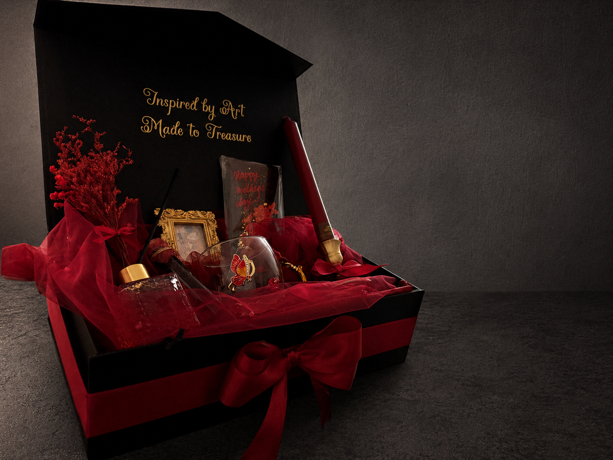 Open Klimt The Kiss gift box displaying red tissue paper and assorted gift items