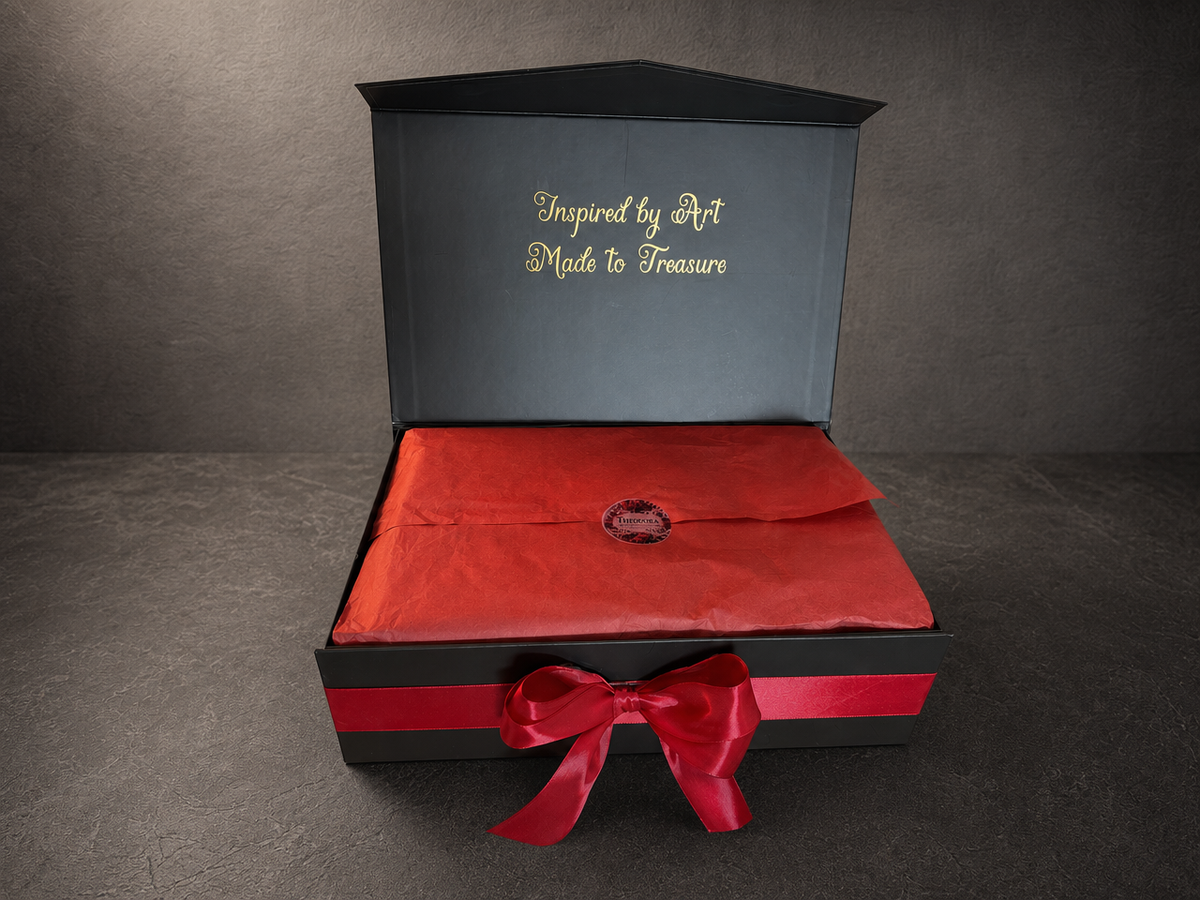 Open black Klimt The Kiss gift box with red tissue paper and ribbon bow